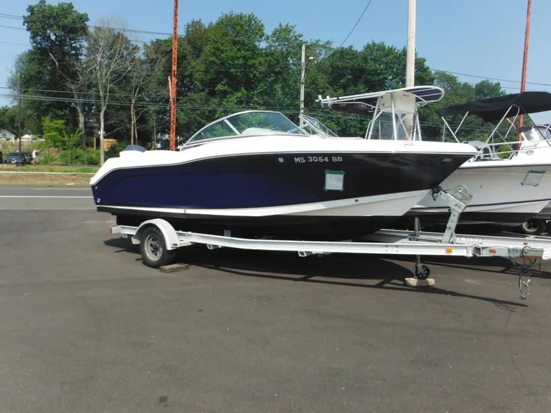 Slide: The Image of 2013 Robalo R207 Dual Console boat on trailer, parked outdoors. - 0