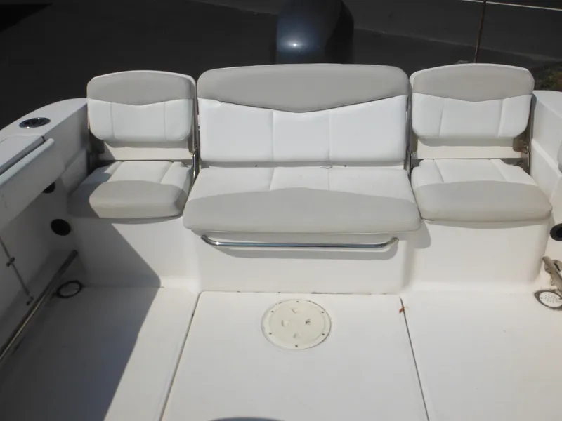 Slide: The Image of 2013 Robalo R207 Dual Console boat seating area with white cushioned seats. - 22