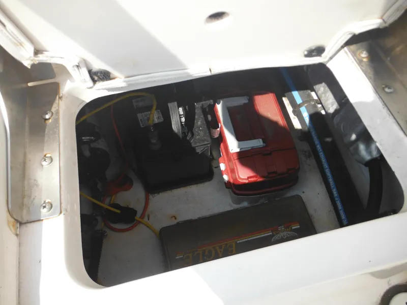 Slide: The Image of 2013 Robalo R207 Dual Console boat battery compartment with wiring and storage. - 24