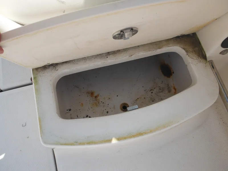 Slide: The Image of Open storage compartment on 2013 Robalo R207 Dual Console boat, showing wear and rust. - 30