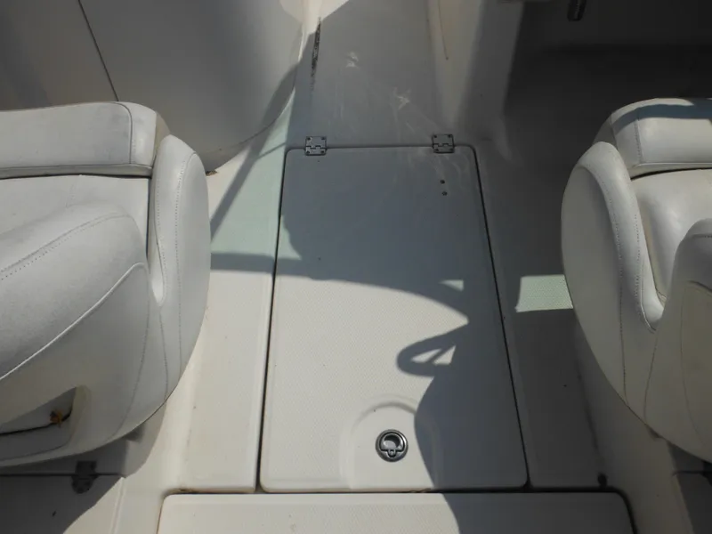 Slide: The Image of 2013 Robalo R207 Dual Console boat interior with white seating and storage compartment. - 34