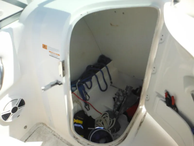 Slide: The Image of Storage compartment in a 2013 Robalo R207 Dual Console boat, containing ropes and equipment. - 37