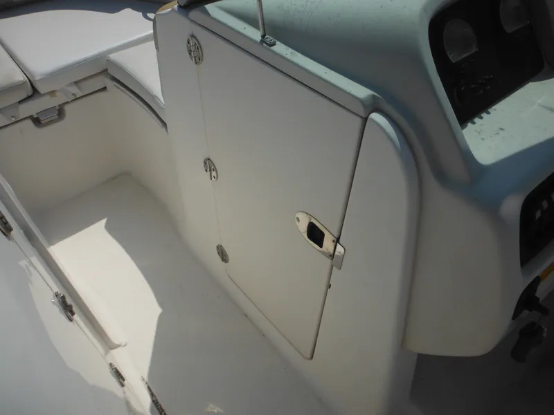 Slide: The Image of 2013 Robalo R207 Dual Console interior with storage compartment and seating area. - 38
