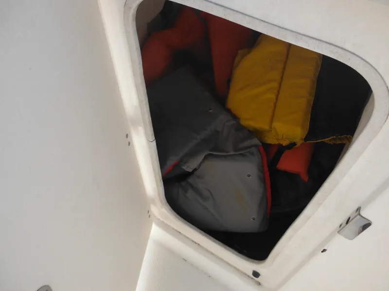 Slide: The Image of Storage compartment with life jackets on a 2013 Robalo R207 Dual Console boat. - 39