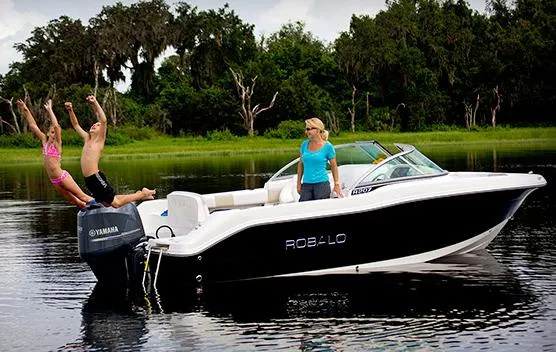 Slide: The Image of Manufacturer Provided Image: 2013 Robalo R207 Dual Console boat with people enjoying water activities. - 4
