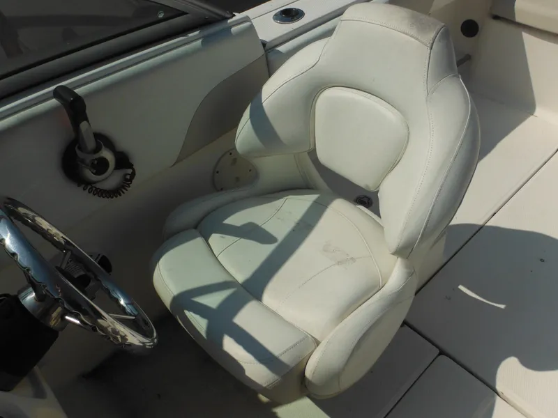 Slide: The Image of 2013 Robalo R207 Dual Console boat interior with white captain's chair and steering wheel. - 44