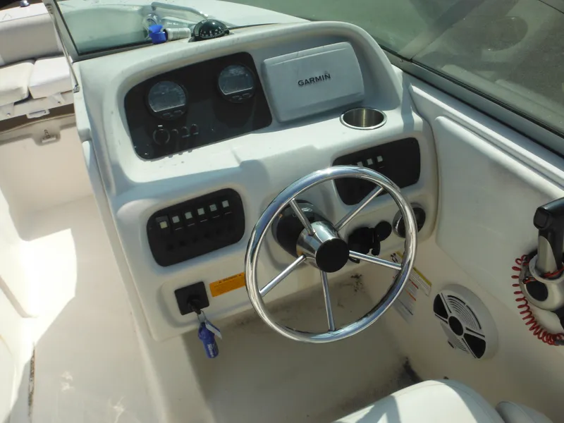 Slide: The Image of 2013 Robalo R207 Dual Console boat dashboard with steering wheel and Garmin navigation system. - 46