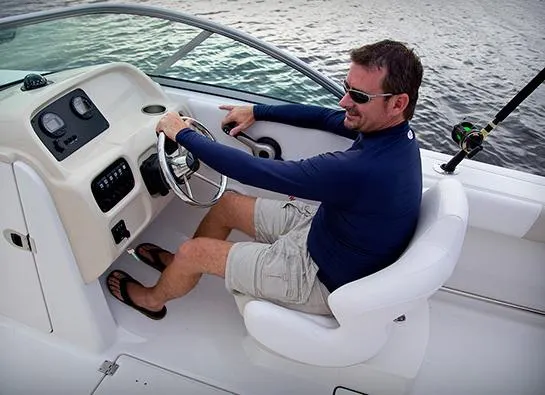 Slide: The Image of Manufacturer Provided Image: Man driving a 2013 Robalo R207 Dual Console boat on the water. - 7