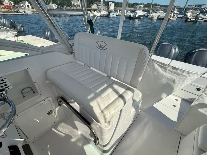 Slide: The Image of 2008 Southport 28 Express boat interior with white seating and marina view. - 16