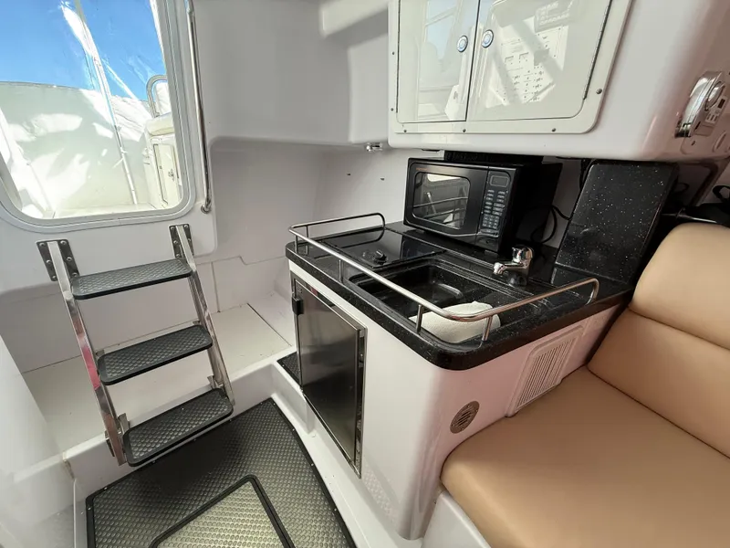 Slide: The Image of Compact kitchen area in a 2008 Southport 28 Express boat with microwave and sink. - 20
