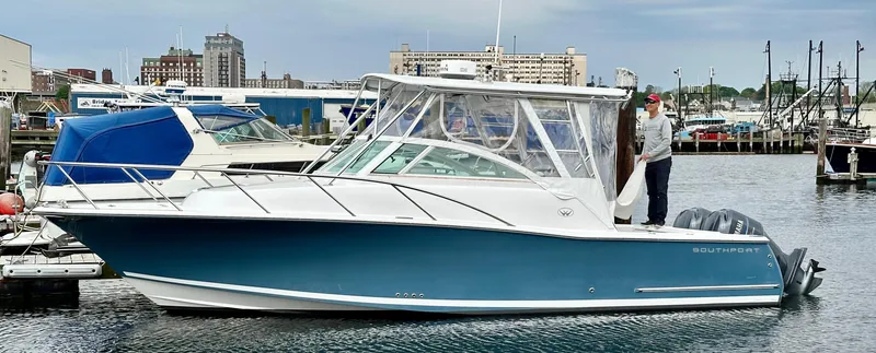 Slide: The Image of 2008 Southport 28 Express boat docked in a marina with a person on board. - 3