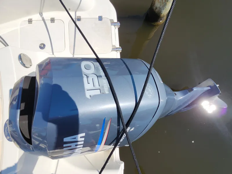 Slide: The Image of Yamaha 150 outboard motor on 2009 Hurricane SunDeck 2000 OB boat, docked in water. - 13