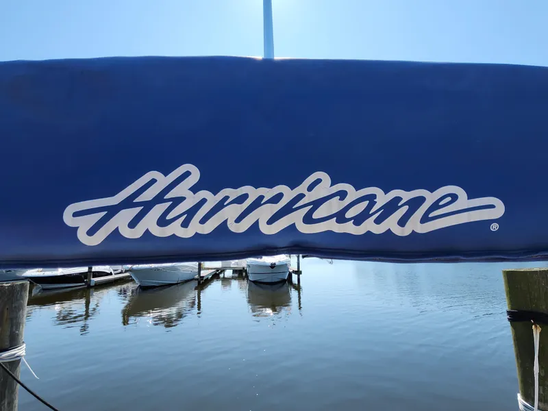 Slide: The Image of Blue cover with "Hurricane" logo on a 2009 SunDeck 2000 OB boat at a marina. - 15