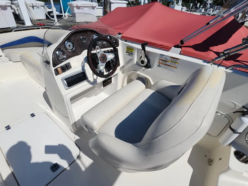 Slide: The Image of 2009 Hurricane SunDeck 2000 OB boat cockpit with steering wheel and seating. - 5