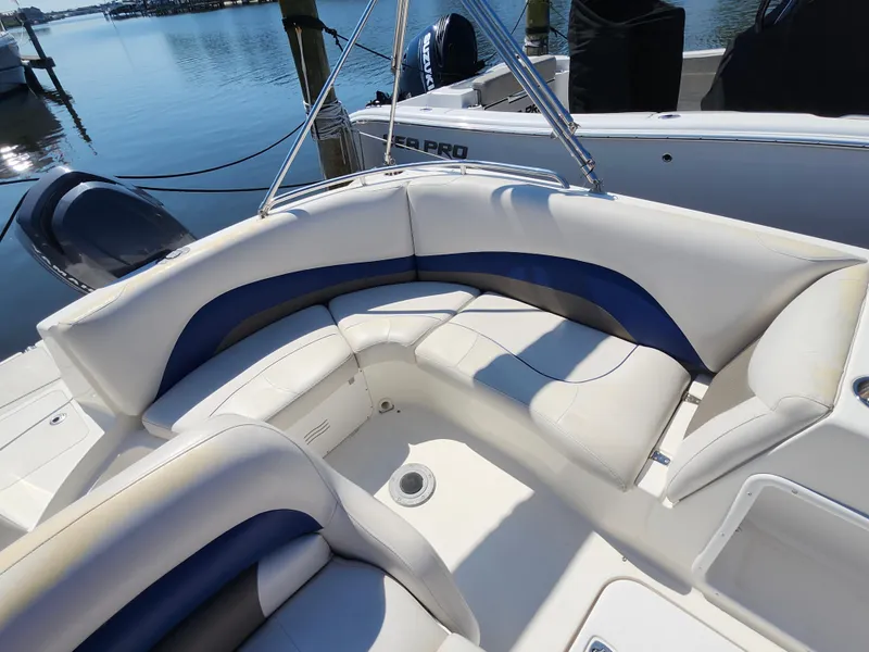 Slide: The Image of 2009 Hurricane SunDeck 2000 OB boat with white and blue seating, docked by the water. - 7