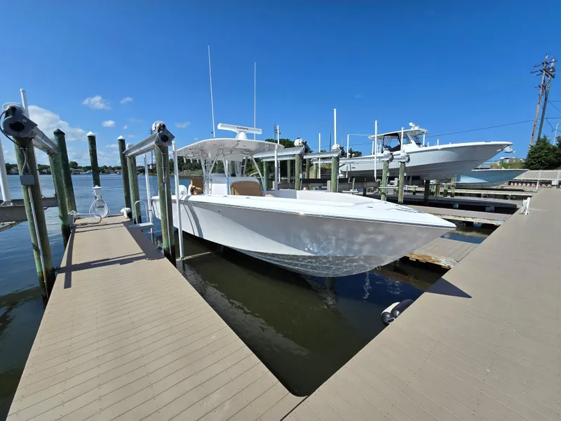 Slide: The Image of 2025 Bahama 35 Super Center Console docked at marina under clear blue sky. - 2