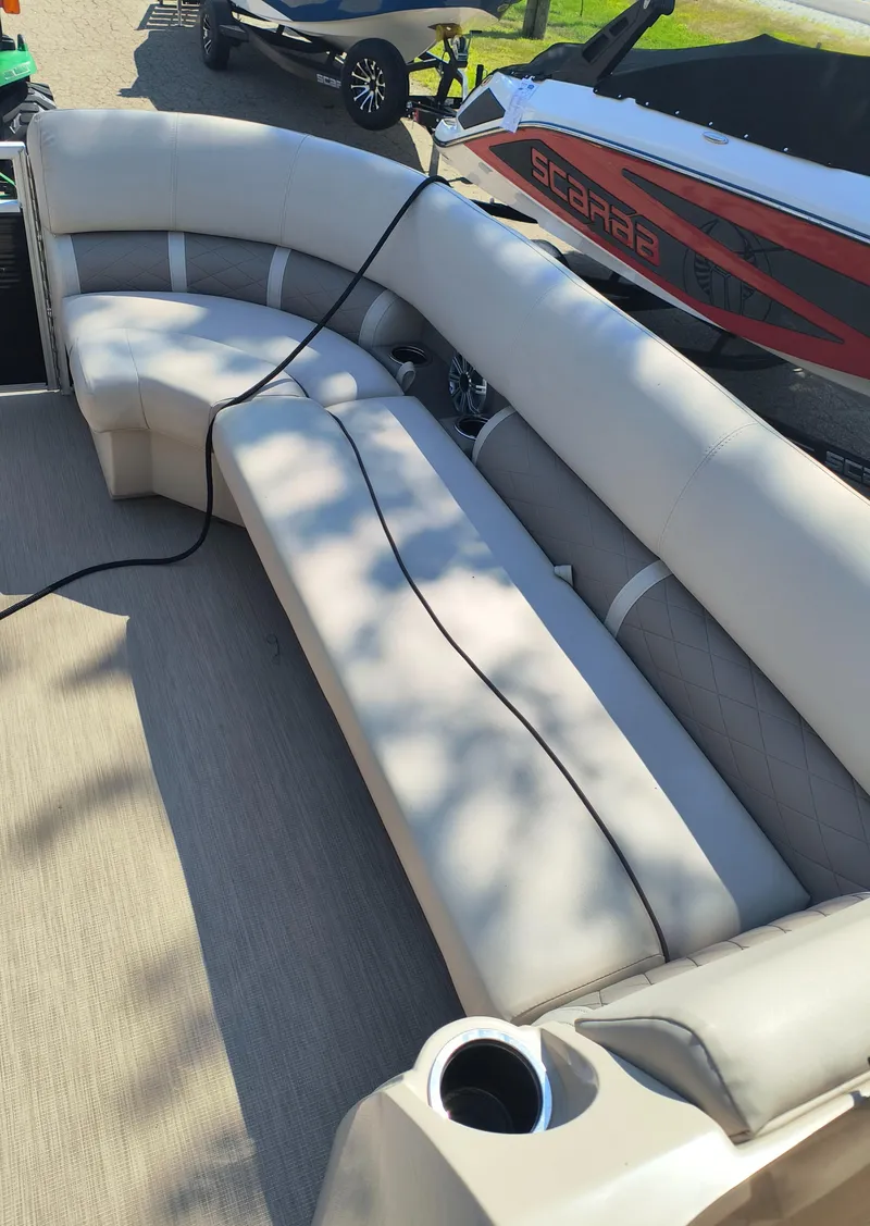 Slide: The Image of 2017 Bennington 24 SSBXP-SPS boat interior with beige seating and cup holder. - 10