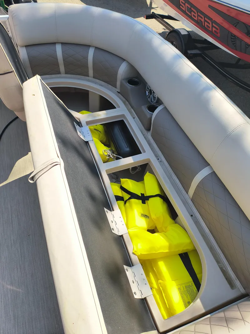 Slide: The Image of 2017 Bennington 24 SSBXP-SPS boat seat storage with yellow life jackets. - 11