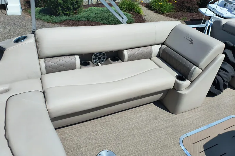 Slide: The Image of 2017 Bennington 24 SSBXP-SPS boat interior with beige seating and cup holders. - 14