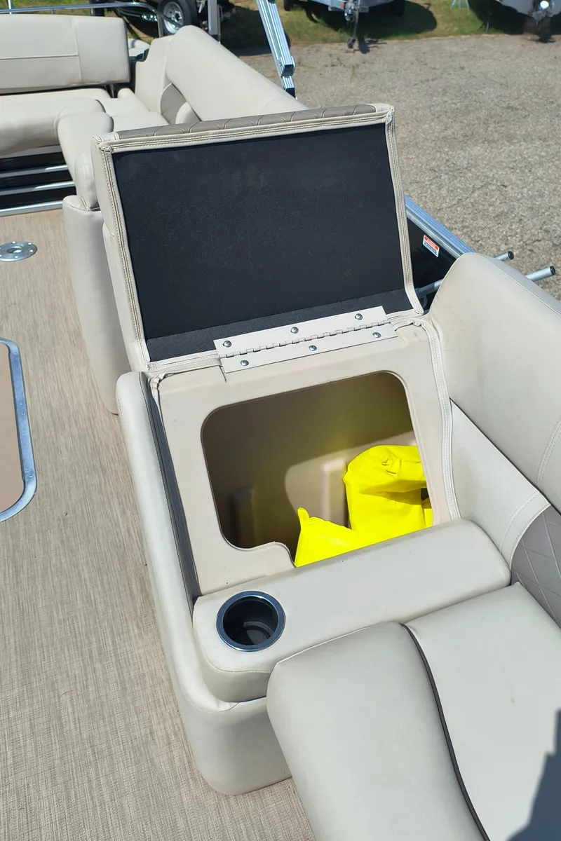Slide: The Image of 2017 Bennington 24 SSBXP-SPS boat seat storage with cup holder and yellow life jackets. - 17