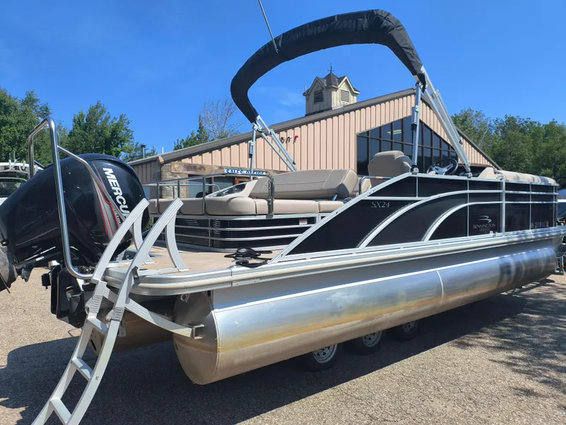 Slide: The Image of 2017 Bennington 24 SSBXP-SPS pontoon boat with Mercury engine, parked outdoors. - 2