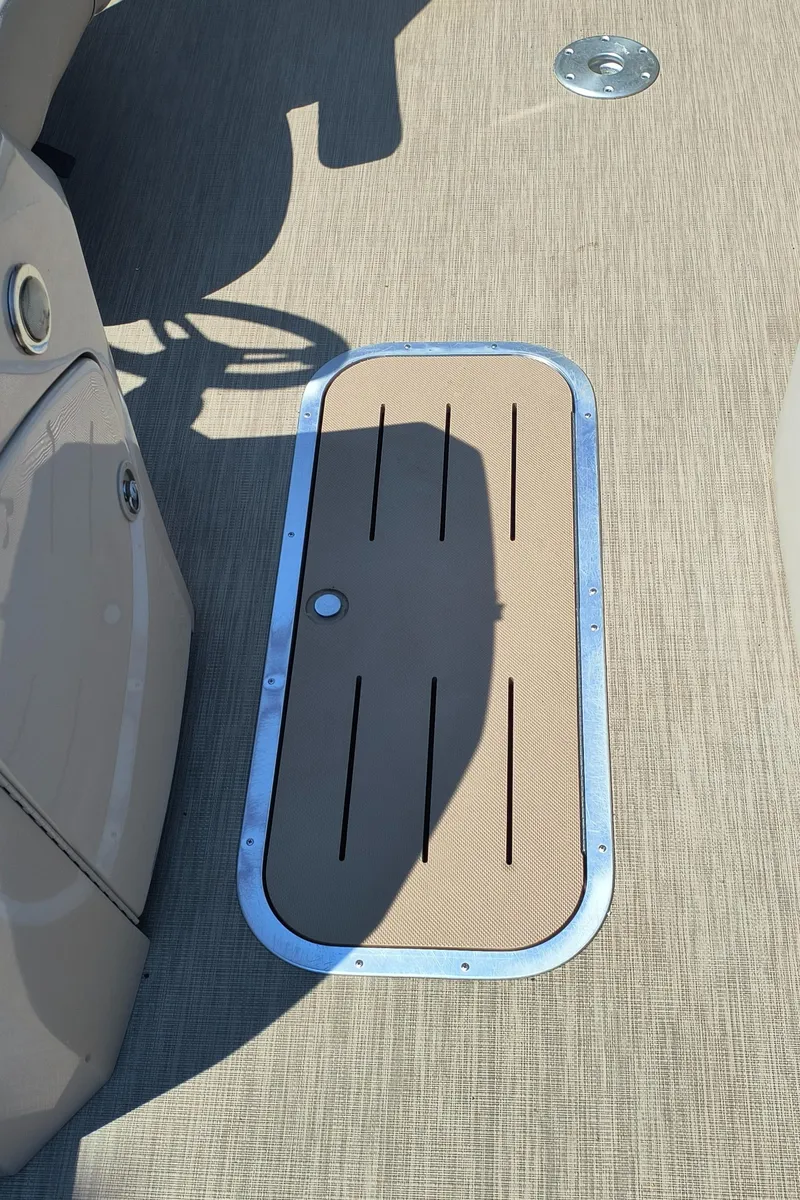 Slide: The Image of 2017 Bennington 24 SSBXP-SPS boat deck with storage hatch and shadow. - 20