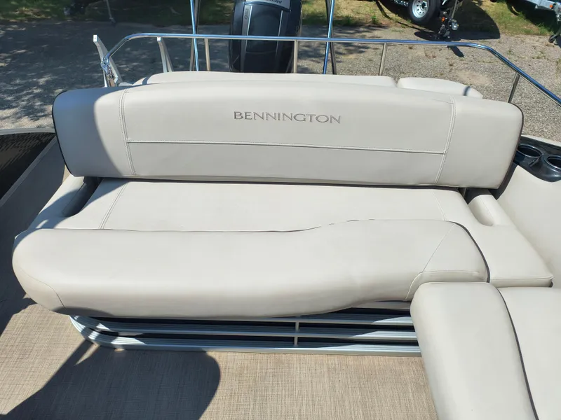 Slide: The Image of 2017 Bennington 24 SSBXP-SPS boat seat with beige upholstery and cup holders. - 24
