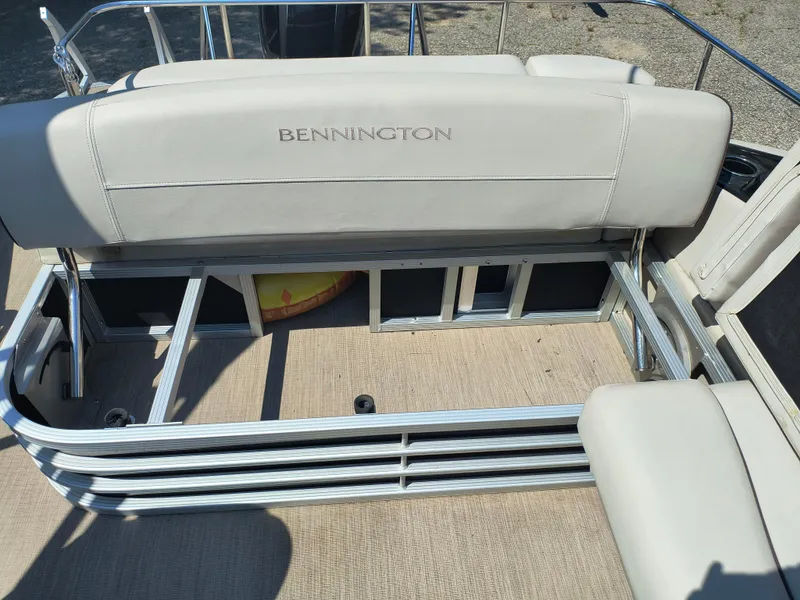 Slide: The Image of 2017 Bennington 24 SSBXP-SPS boat interior with beige seating and metal railing. - 25