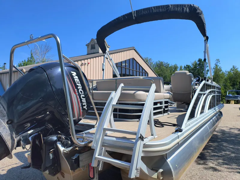 Slide: The Image of 2017 Bennington 24 SSBXP-SPS pontoon boat with Mercury outboard motor, parked outdoors. - 5