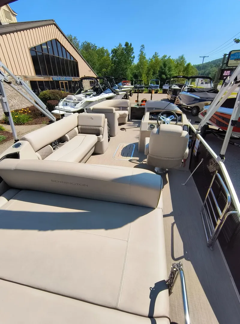 Slide: The Image of 2017 Bennington 24 SSBXP-SPS pontoon boat with beige seating, displayed outdoors. - 7