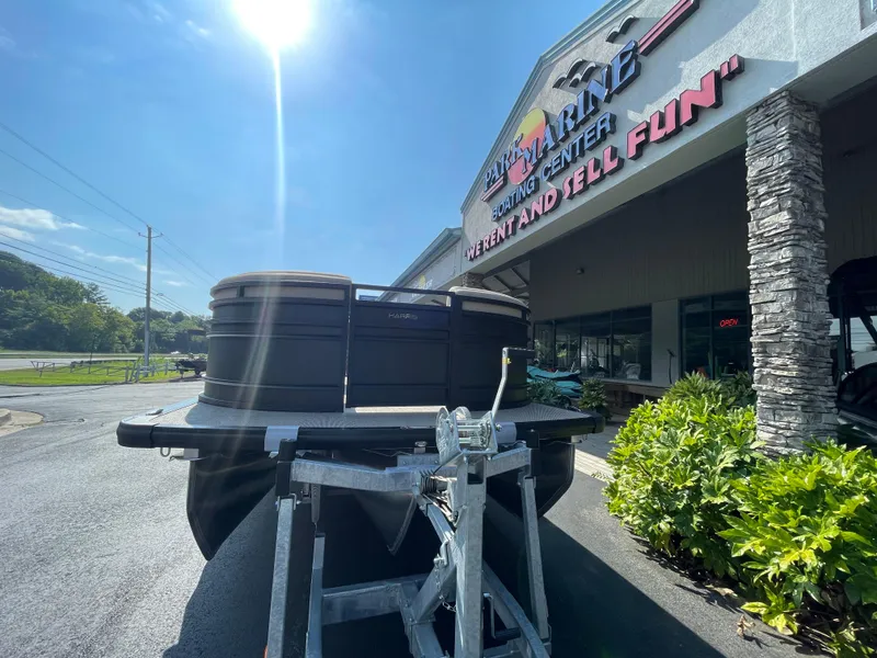Slide: The Image of 2026 Harris Solstice 230 boat on trailer outside marine center under bright sun. - 4