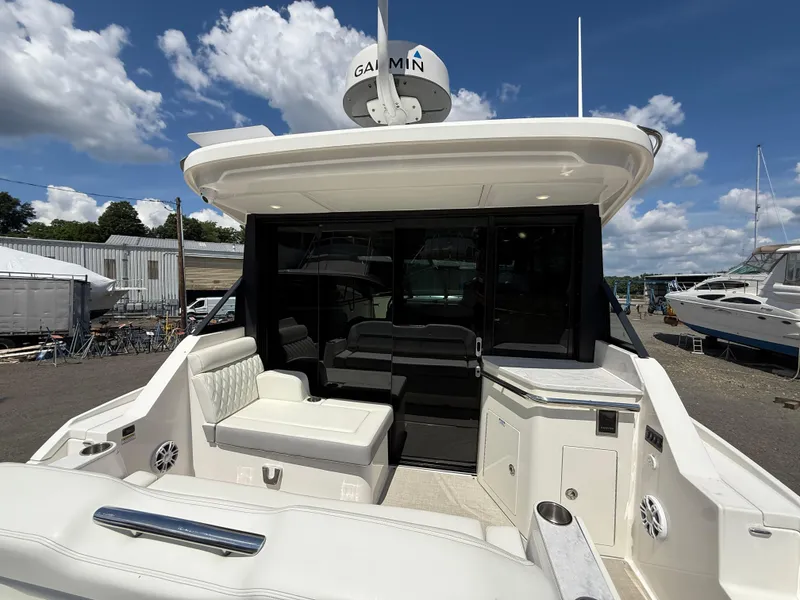 Slide: The Image of 2022 Regal 36 XO yacht with spacious seating and modern design under a clear sky. - 14