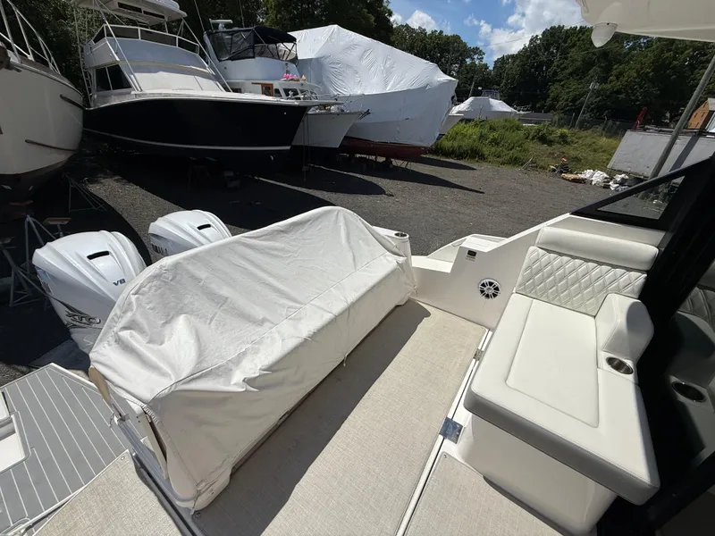 Slide: The Image of 2022 Regal 36 XO boat interior with covered seating and twin outboard engines. - 17