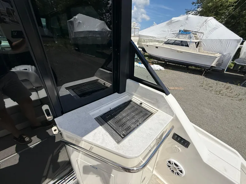 Slide: The Image of 2022 Regal 36 XO boat interior with grill and seating area. - 22