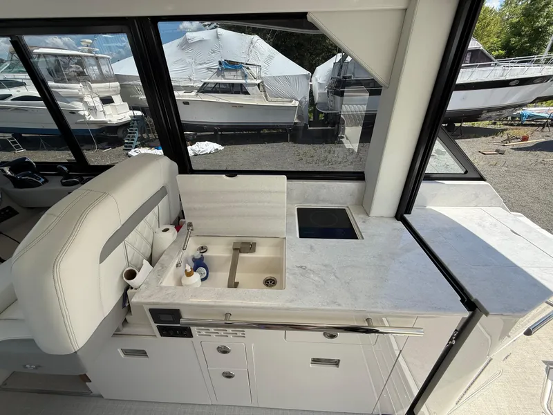 Slide: The Image of 2022 Regal 36 XO yacht interior with modern kitchenette and scenic marina view. - 27