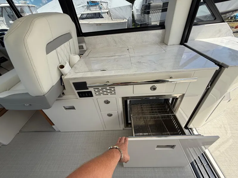 Slide: The Image of 2022 Regal 36 XO yacht interior with open drawer and modern kitchen amenities. - 29