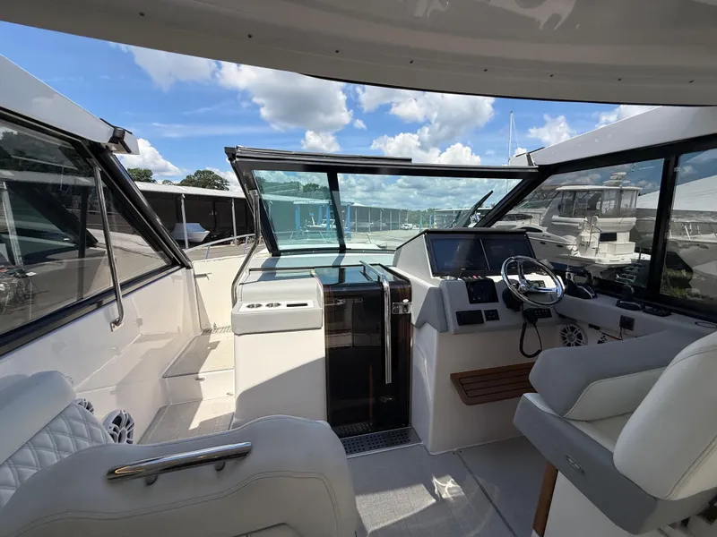 Slide: The Image of 2022 Regal 36 XO yacht cockpit with modern steering and navigation controls. - 37