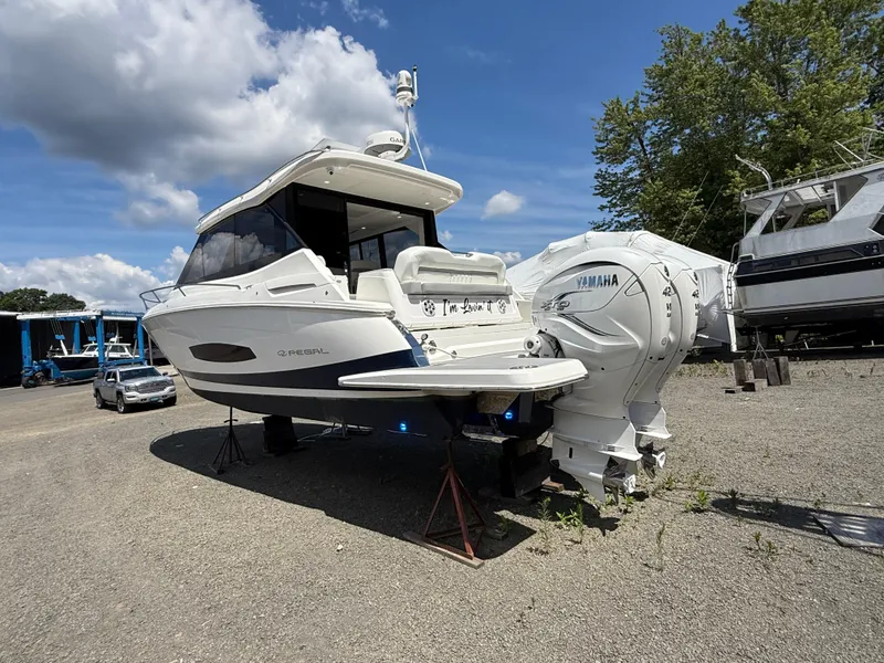 Slide: The Image of 2022 Regal 36 XO boat with Yamaha engines on a gravel lot under a blue sky. - 4