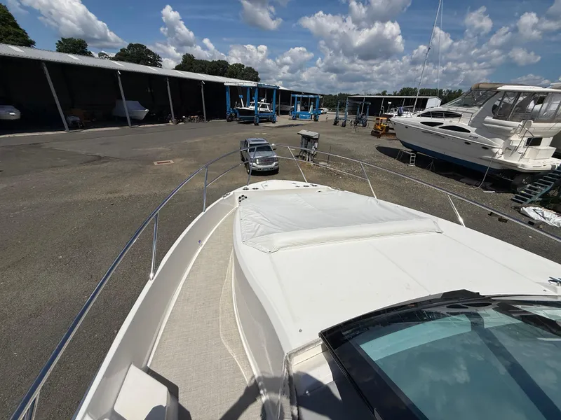 Slide: The Image of 2022 Regal 36 XO yacht in a marina with other boats and vehicles. - 41