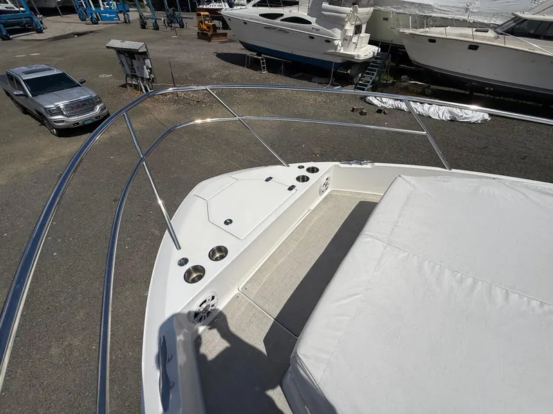 Slide: The Image of 2022 Regal 36 XO boat deck with seating and cup holders in a marina. - 42