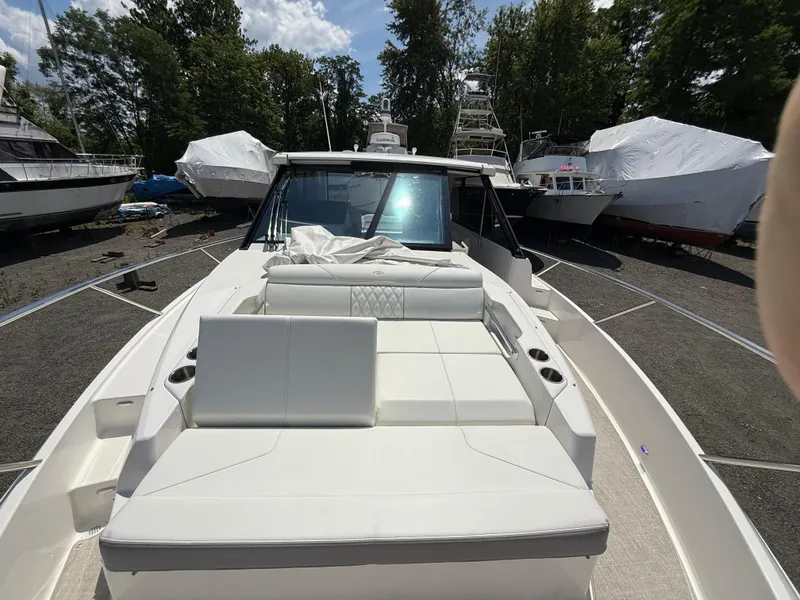 Slide: The Image of 2022 Regal 36 XO yacht with spacious deck, surrounded by other boats in a marina. - 44