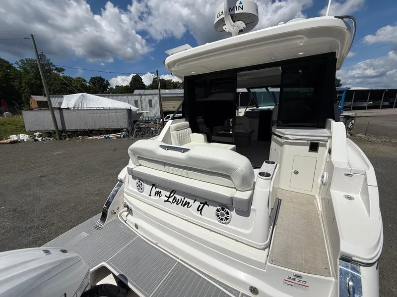 Slide: The Image of 2022 Regal 36 XO yacht with open deck and seating, docked outdoors. - 7