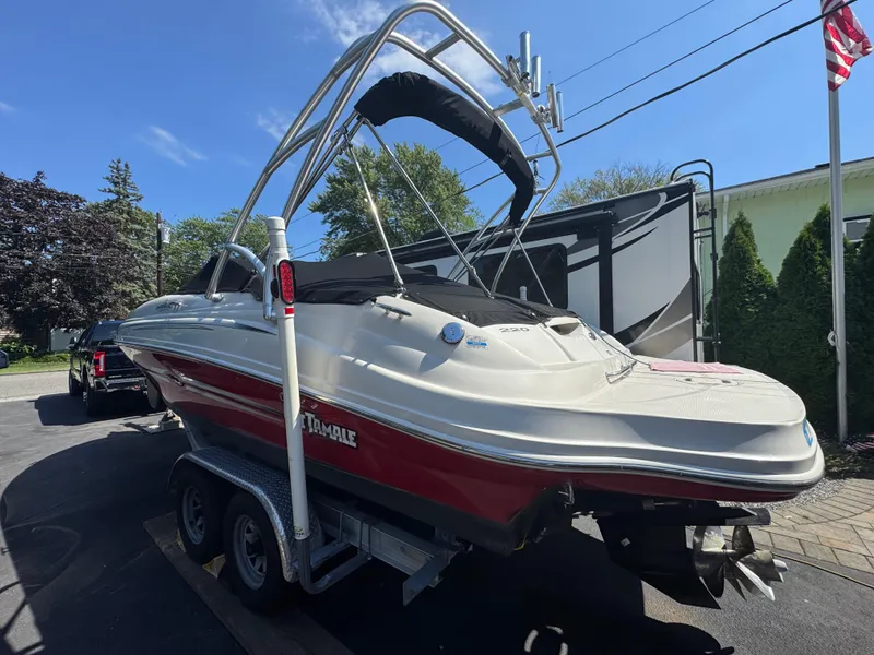 Slide: The Image of 2007 Sea Ray 220 Sundeck boat on trailer, parked outdoors under clear sky. - 2
