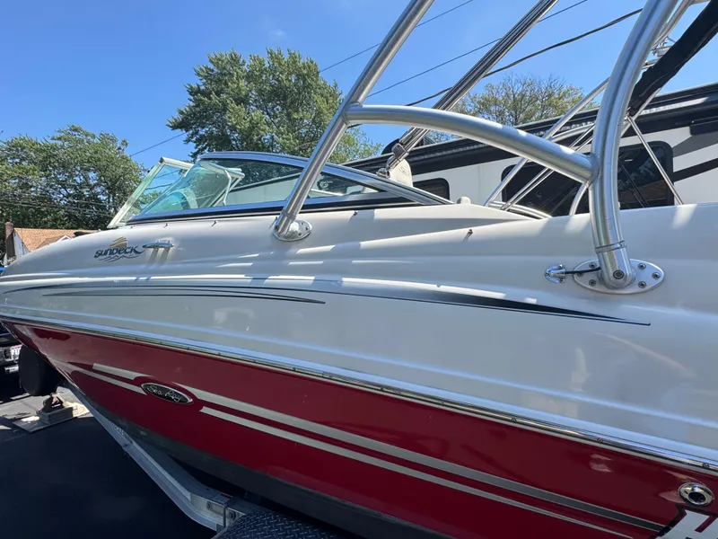 Slide: The Image of 2007 Sea Ray 220 Sundeck boat with red and white exterior, parked outdoors. - 3