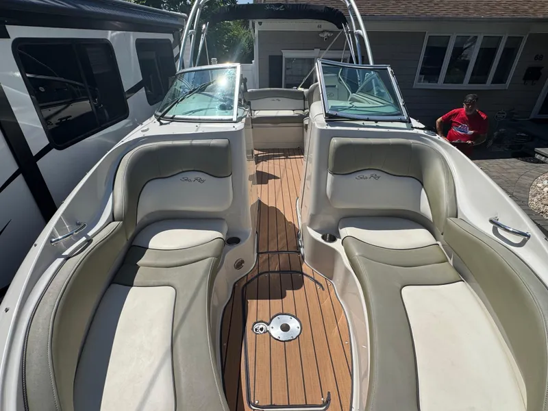Slide: The Image of 2007 Sea Ray 220 Sundeck boat interior with cushioned seating and wooden flooring. - 4