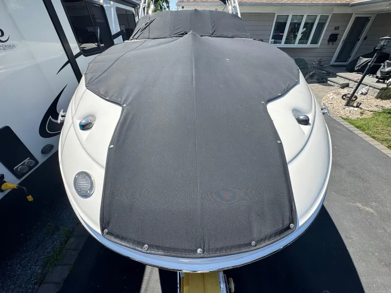 Slide: The Image of 2007 Sea Ray 220 Sundeck boat with black cover, parked in driveway. - 5