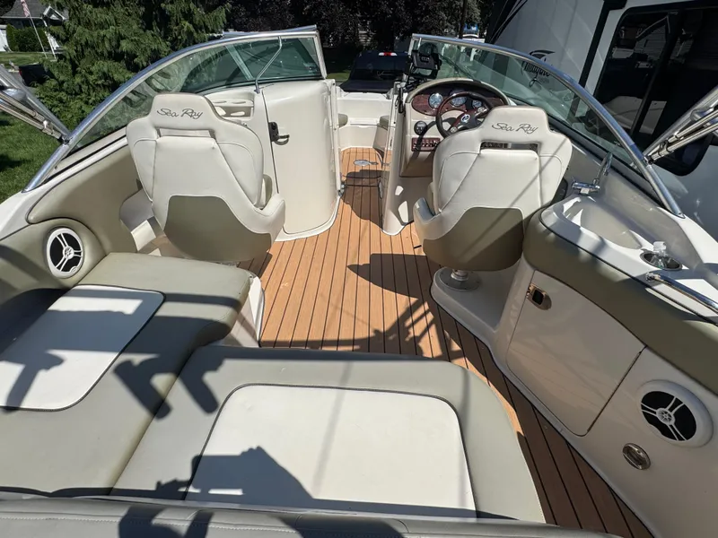 Slide: The Image of 2007 Sea Ray 220 Sundeck interior with beige seating and wood-style flooring. - 6
