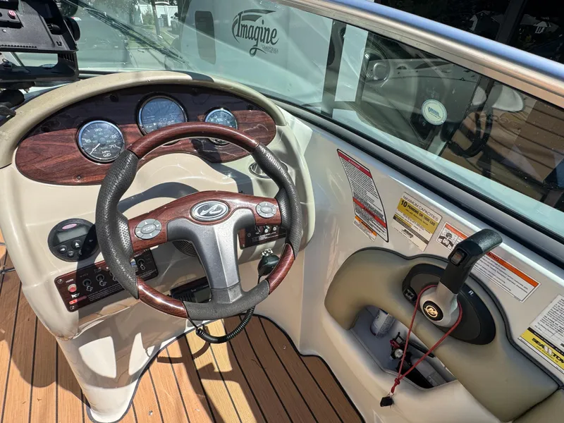 Slide: The Image of 2007 Sea Ray 220 Sundeck dashboard with steering wheel and control panel. - 7
