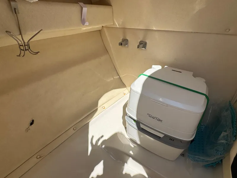 Slide: The Image of Interior of 2007 Sea Ray 220 Sundeck with portable toilet and hooks. - 8