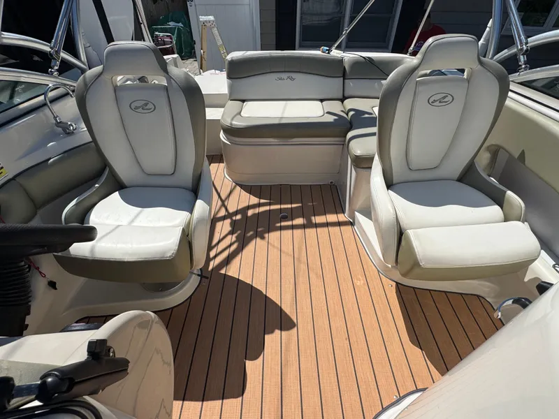 Slide: The Image of 2007 Sea Ray 220 Sundeck interior with white seating and wooden deck. - 9